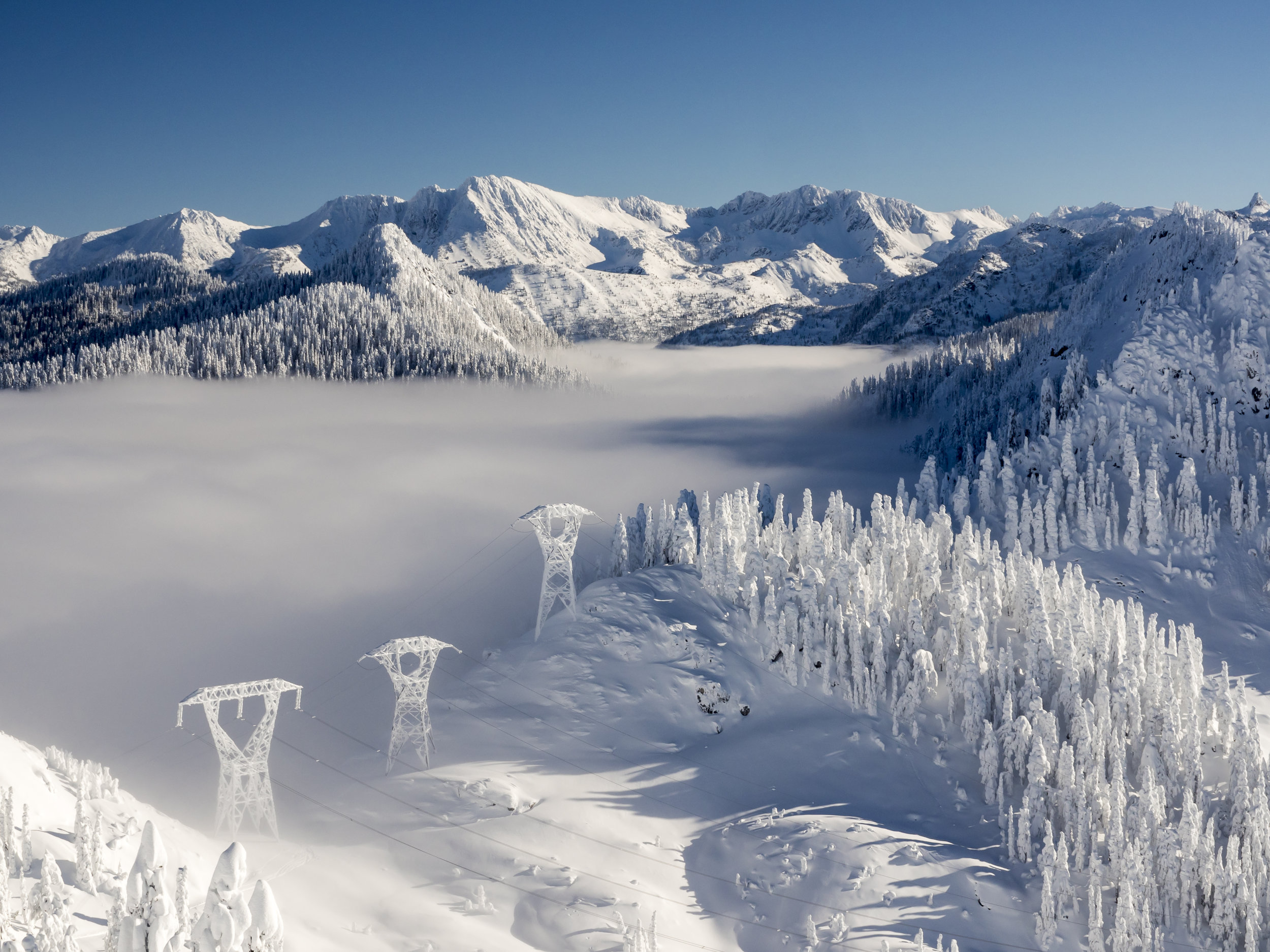 Beautiful Blue Sky Day in Mountain Valley with Winter Snow and Haze Fog Layer