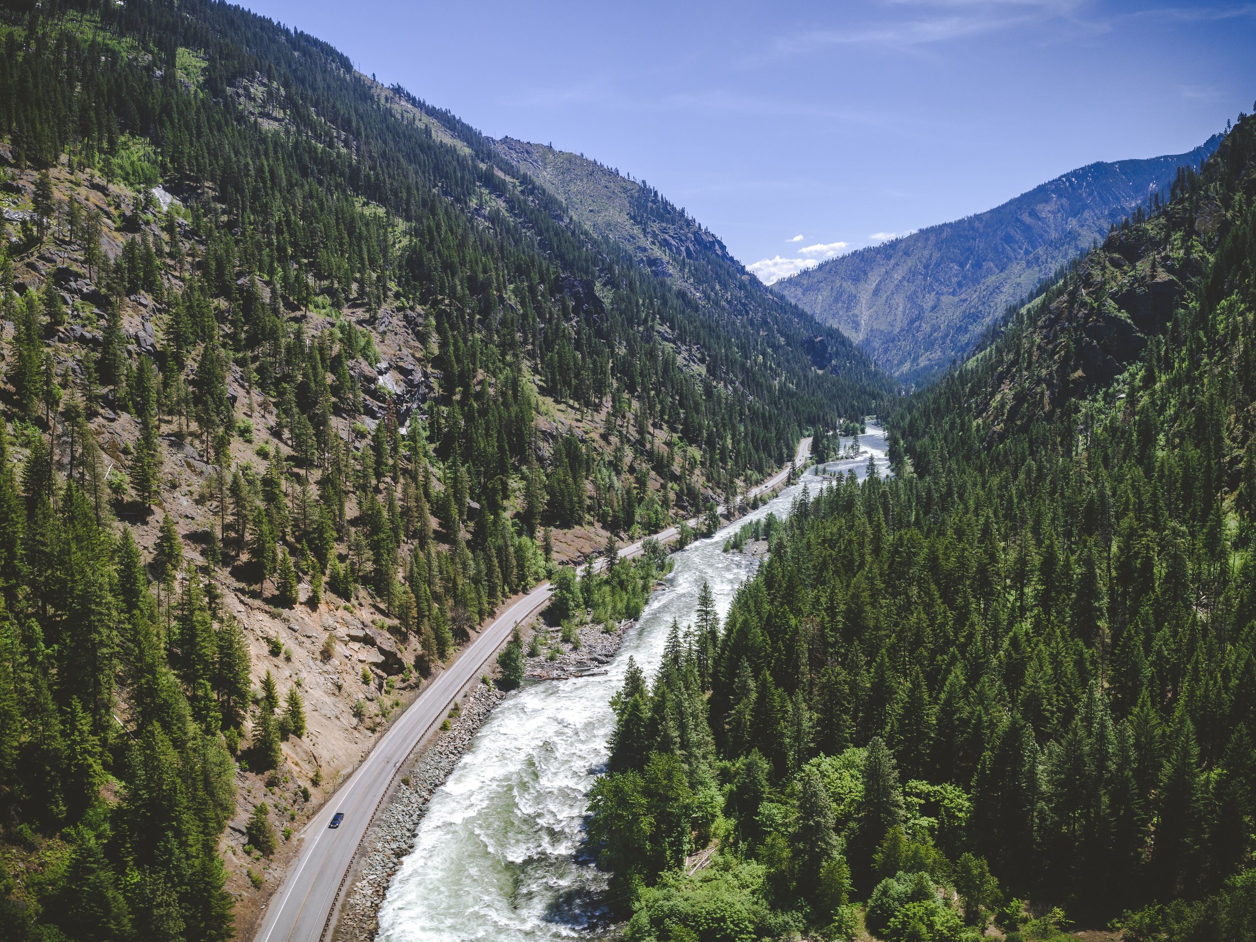 Aerial_of_Scenic_Wilderness_Highway_by_Mountain_River.jpeg