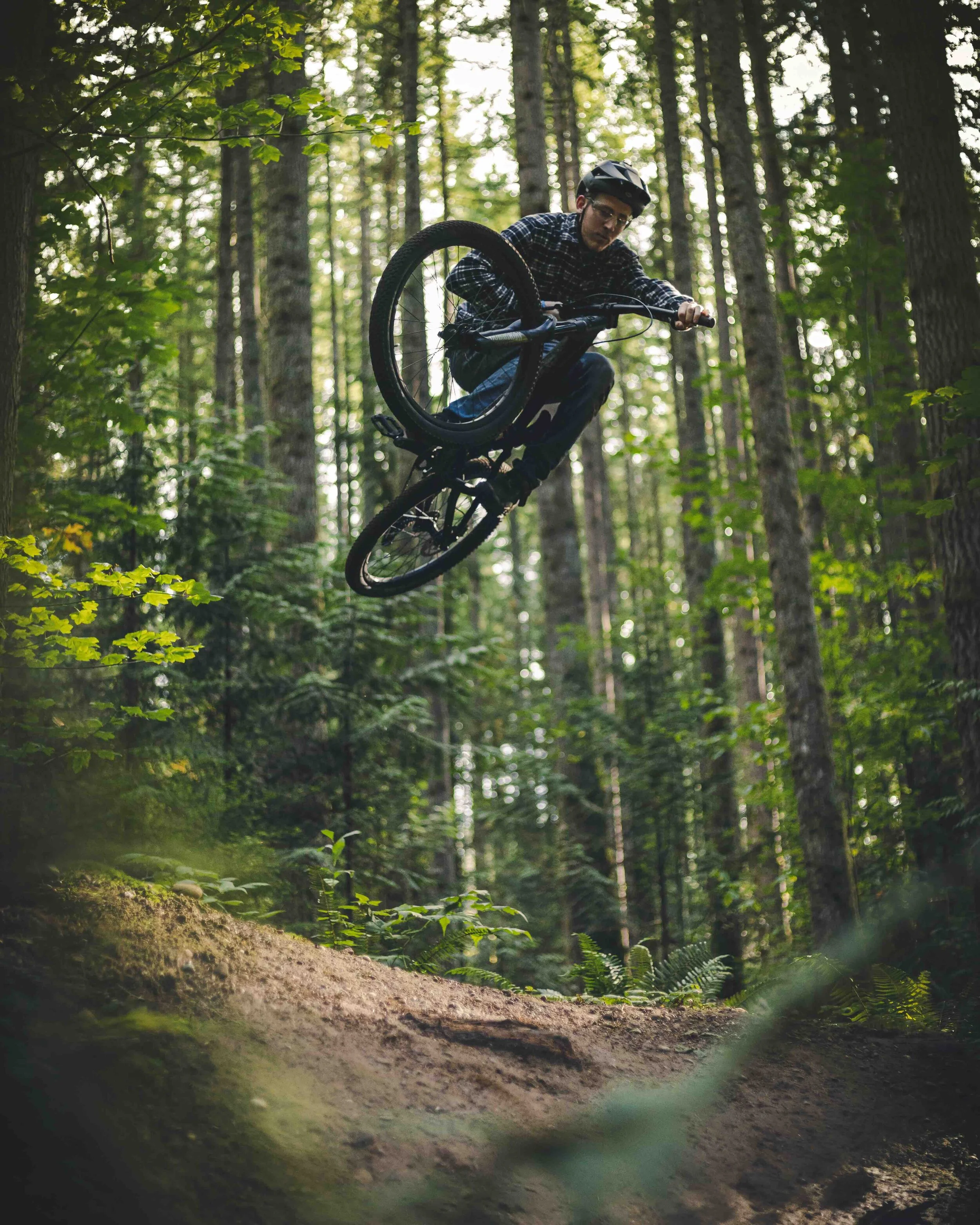 Artistic_Mountain_Bike_Jump_Air_Framed_by_Forest_Foliage.jpeg