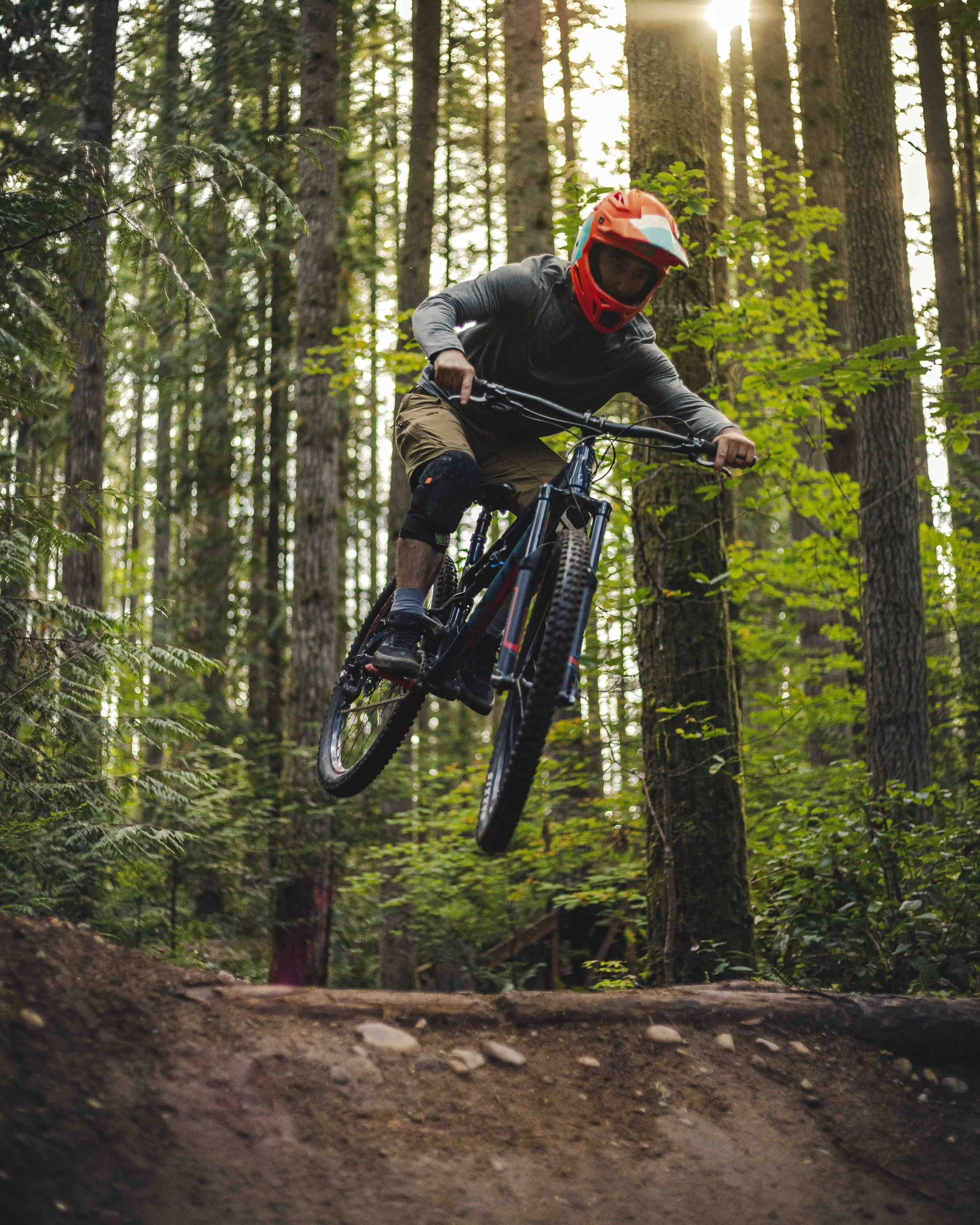 Mountain_Bike_Dirt_Jump_Action_Shot_Mid_Air_with_Forest_Background.jpeg