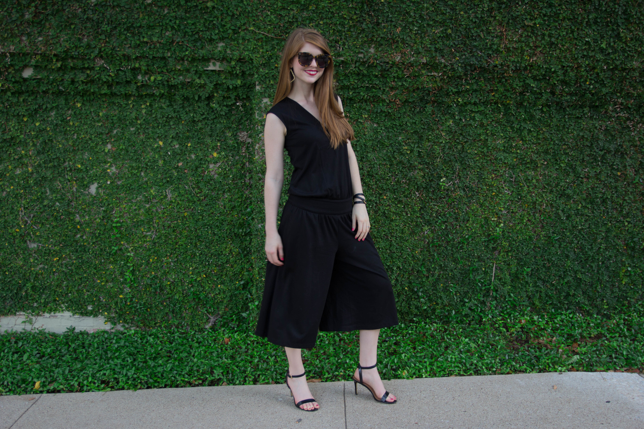cultro clothing, nyc. black culotte jumpsuit, karen walker sunglasses, tory burch strappy sandal,