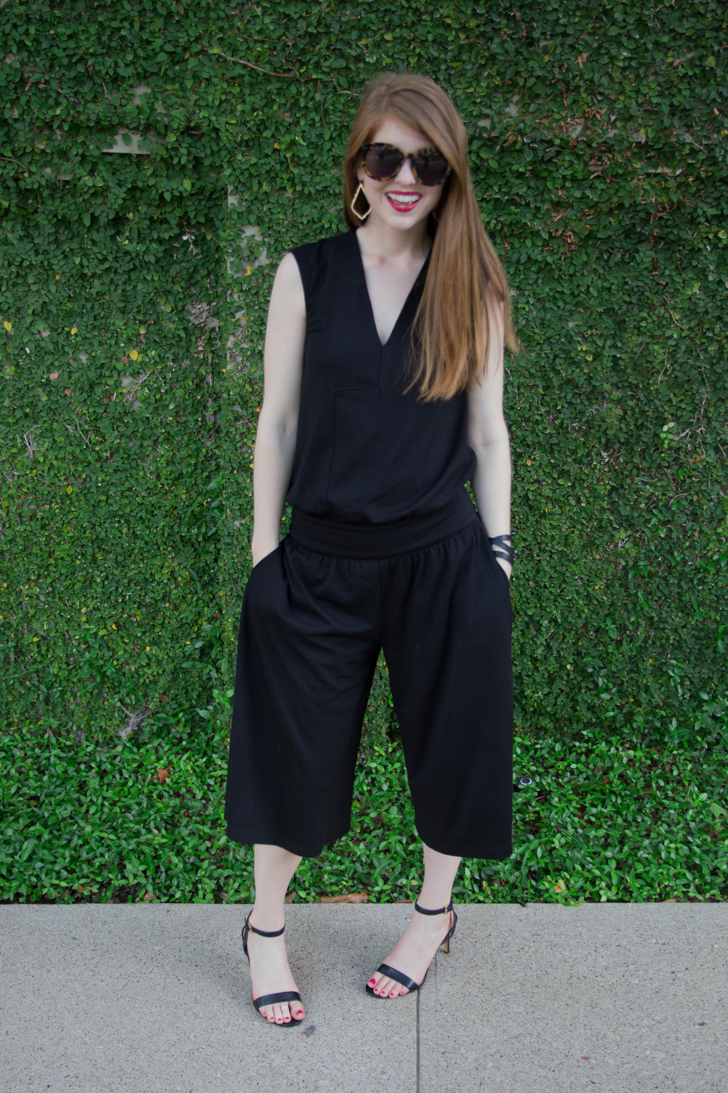 cultro clothing, nyc. black culotte jumpsuit, karen walker sunglasses, tory burch strappy sandal,