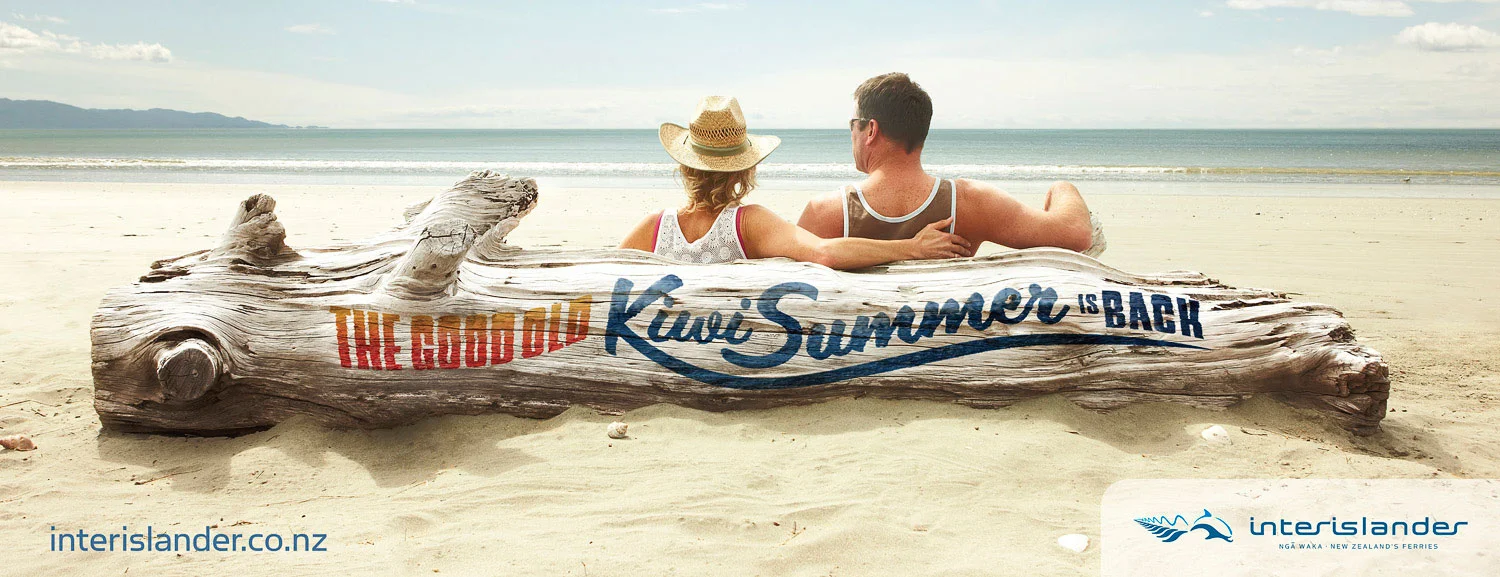 Couple relaxing against a log on the beach