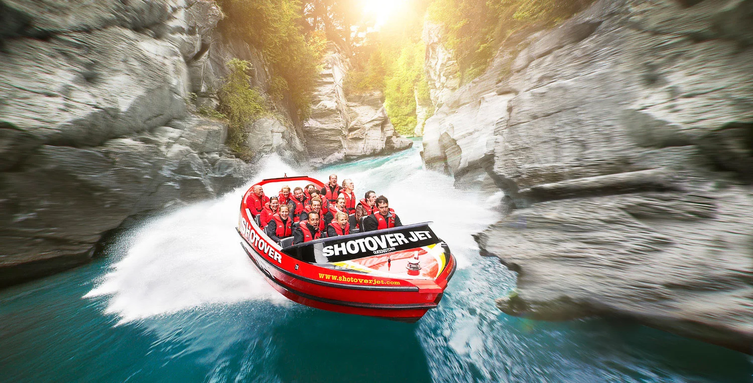 Shotover jet boat speeding next rock cliffs of Shotover River