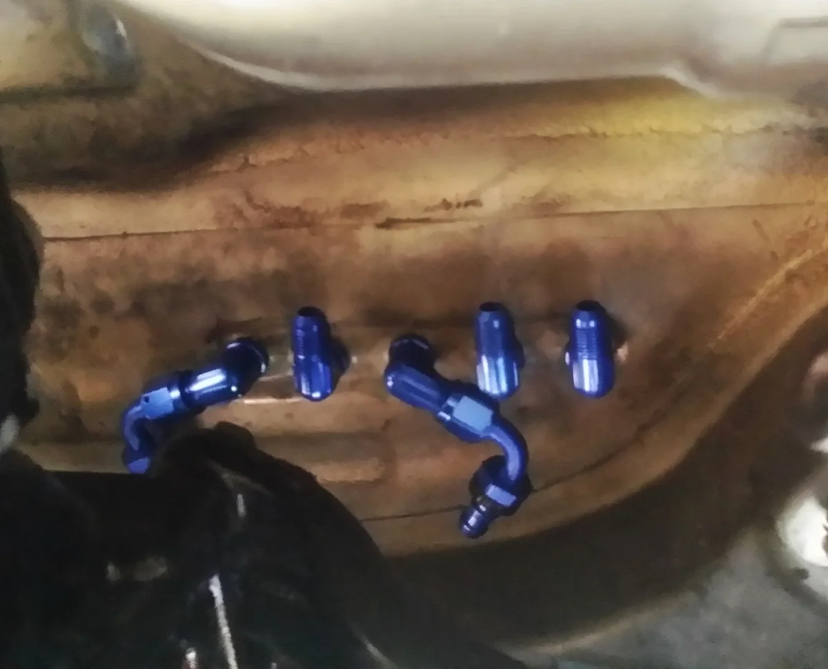 Underside of the fuel surge tank bulkhead fittings just to the left of the rear differential.