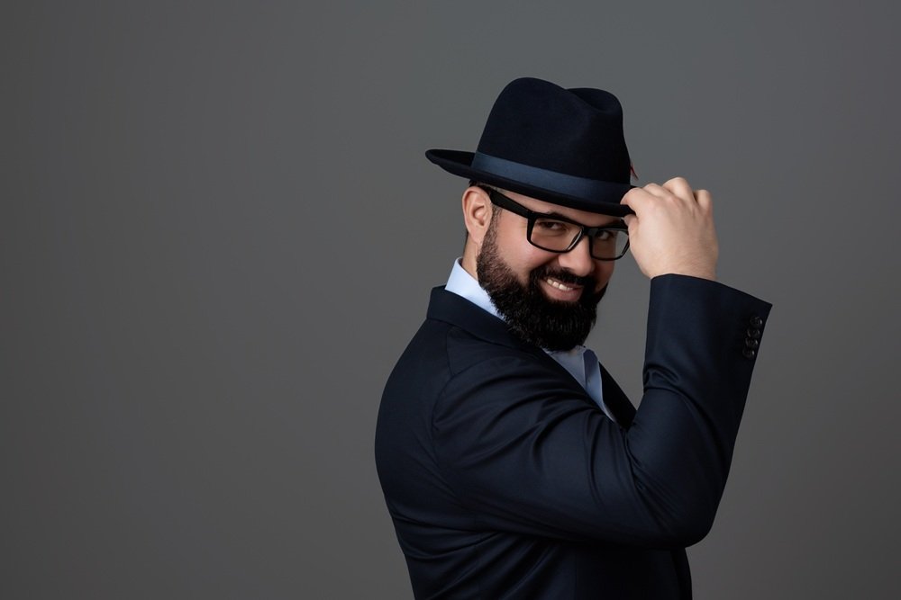 author headshot man with fedora