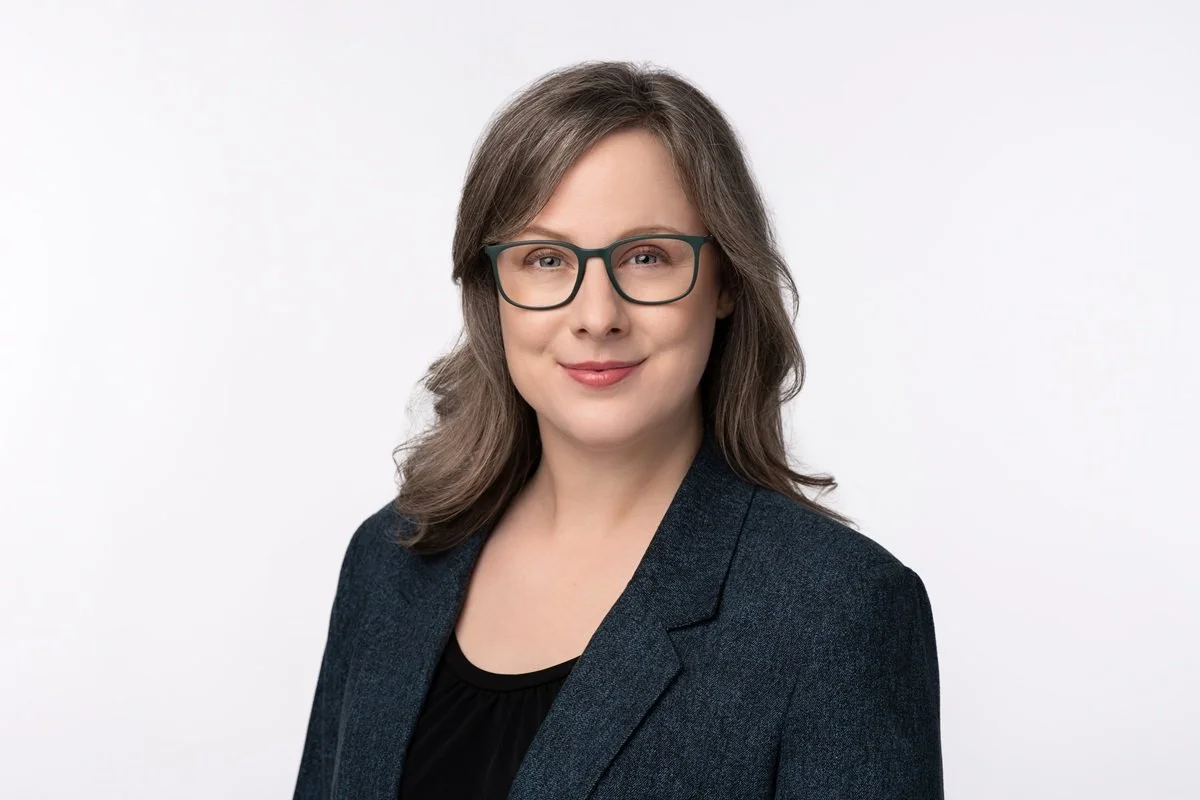 clean classic headshot of woman with glasses