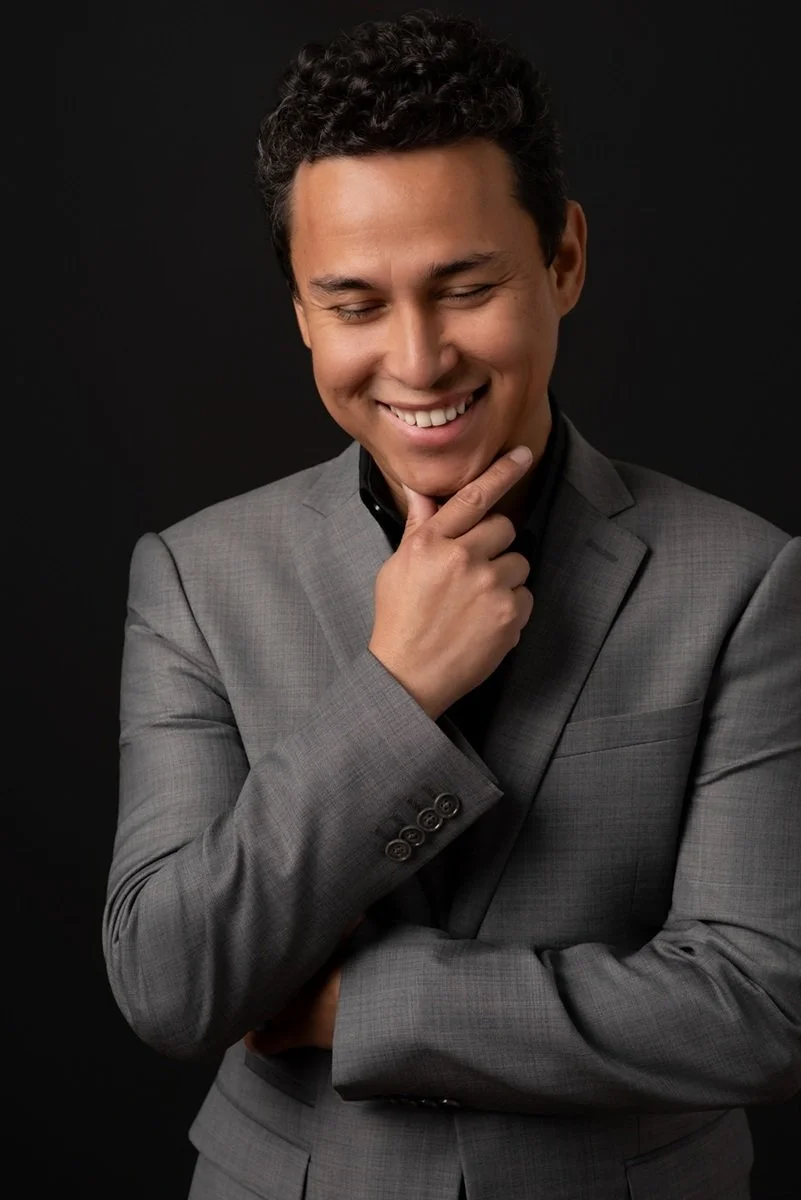 candid headshot man laughing with dark background