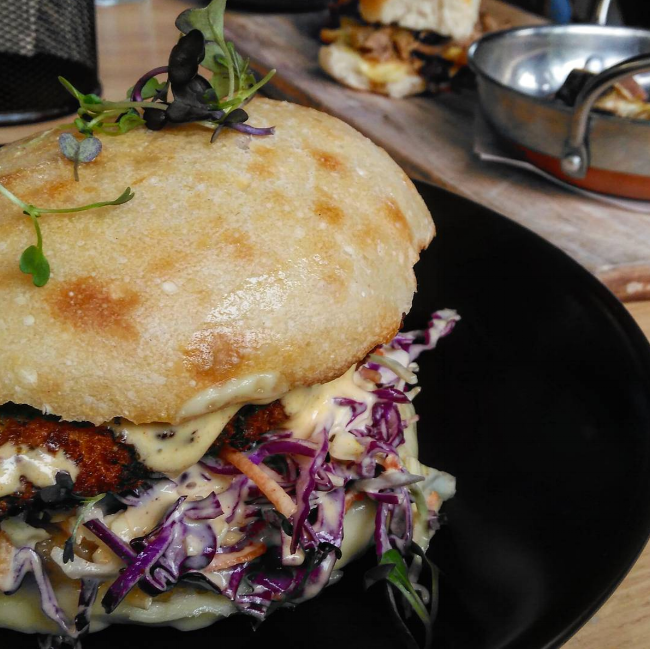 Southern fried chicken burger with fresh slaw. In the background you can see Dad's pulled pork sliders with kumara fries.