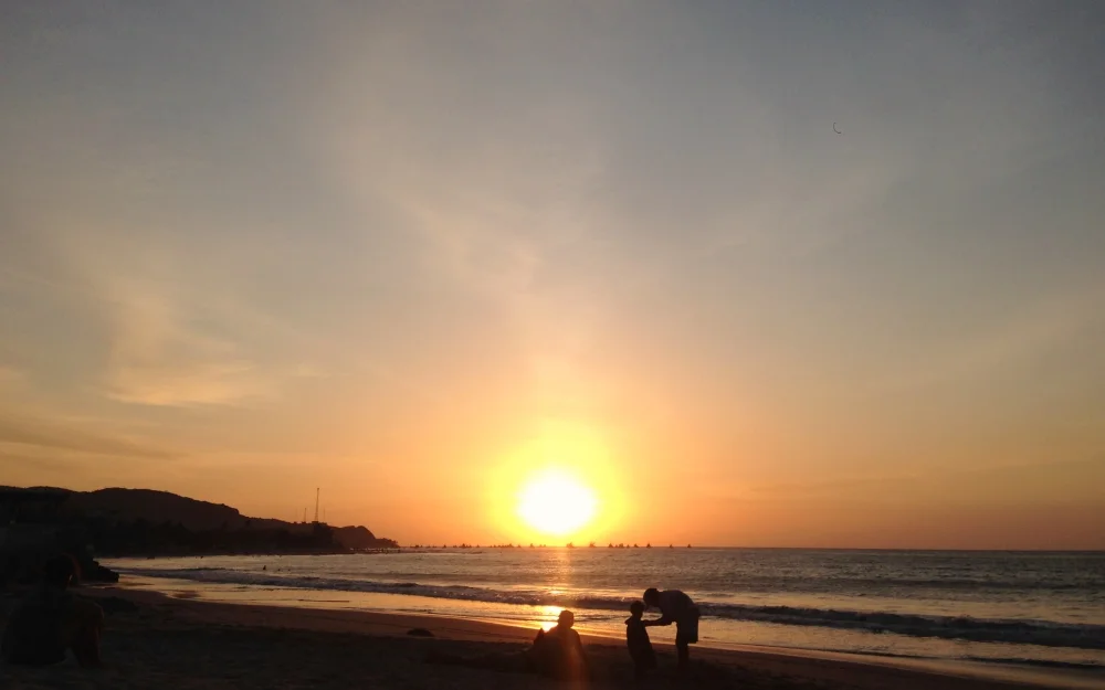 A family at the beach watching the sunset before heading home.