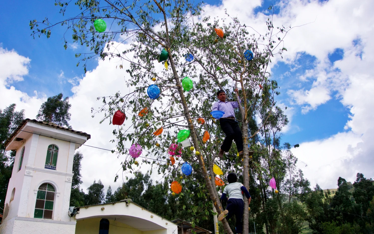 One of the men from Unchus helps to get the presents on top of the tree.