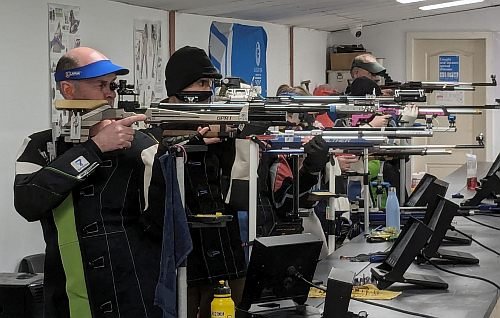 Photo of 4 rifle shooters taking aim on the firing point during a grand prix