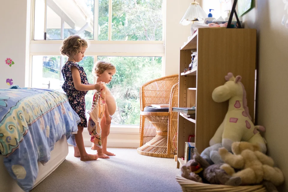 Helping her little sister get dressed