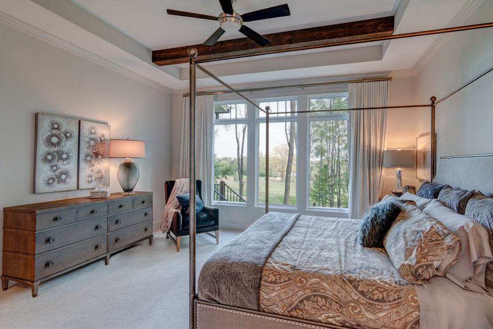 Large windows bring in the maximum natural light in this master bedroom.
