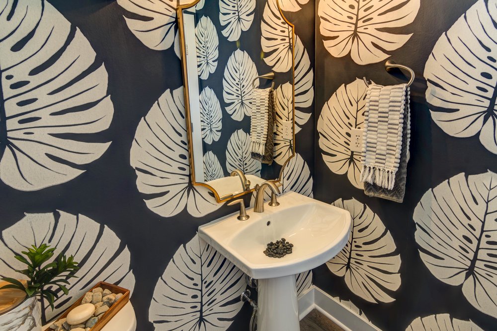 Black and white textured wallpaper adorns the powder bath in the Sycamore model.