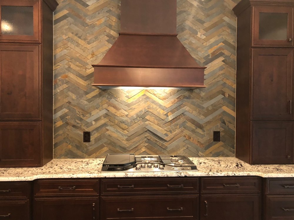 This natural stone backsplash creates a rustic feel throughout this kitchen.