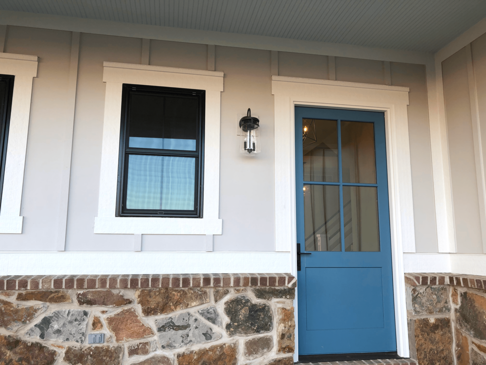 This vibrant blue door stands out against the cream and white siding.