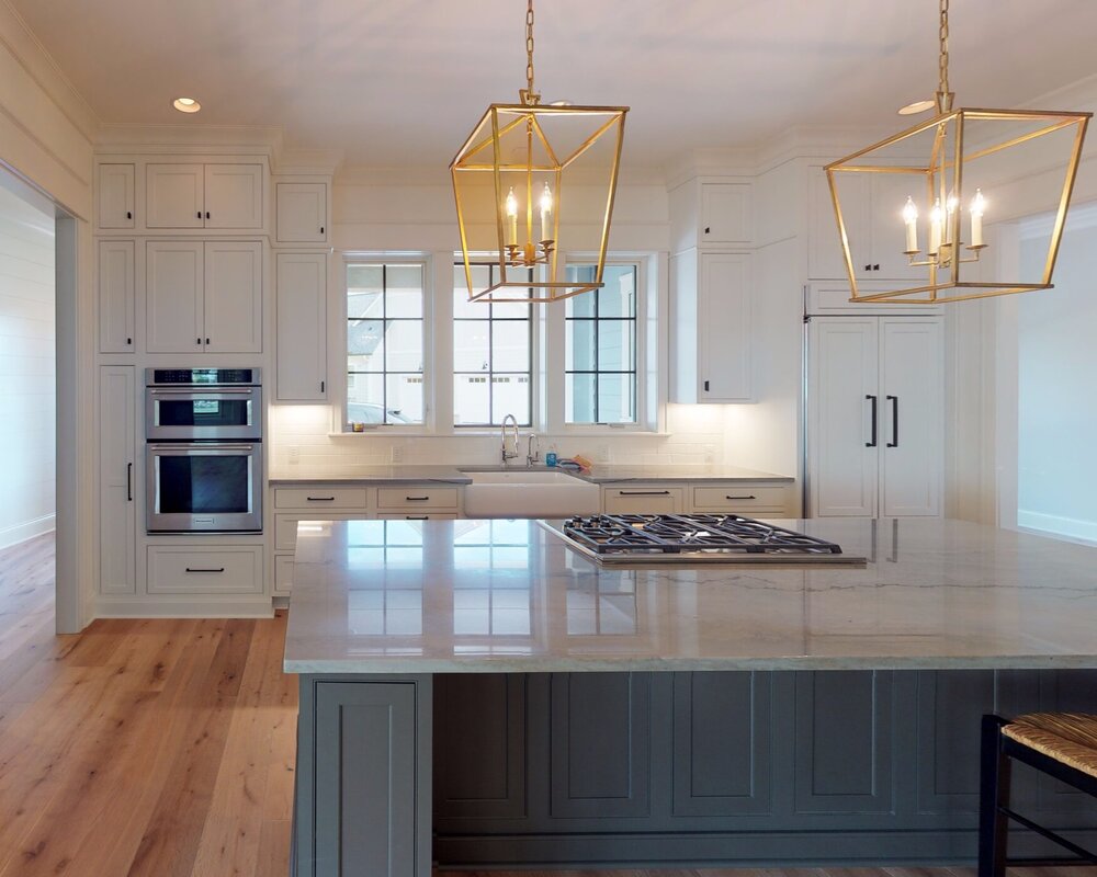 Two-tone cabinets often feature a lighter cabinet along the perimeter of a room and a darker/jewel tone on the island.