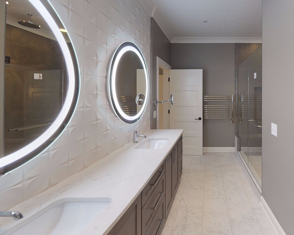 A crisp white textured tile adds to the modern effect of this master bath. Designed by  10inHouse .