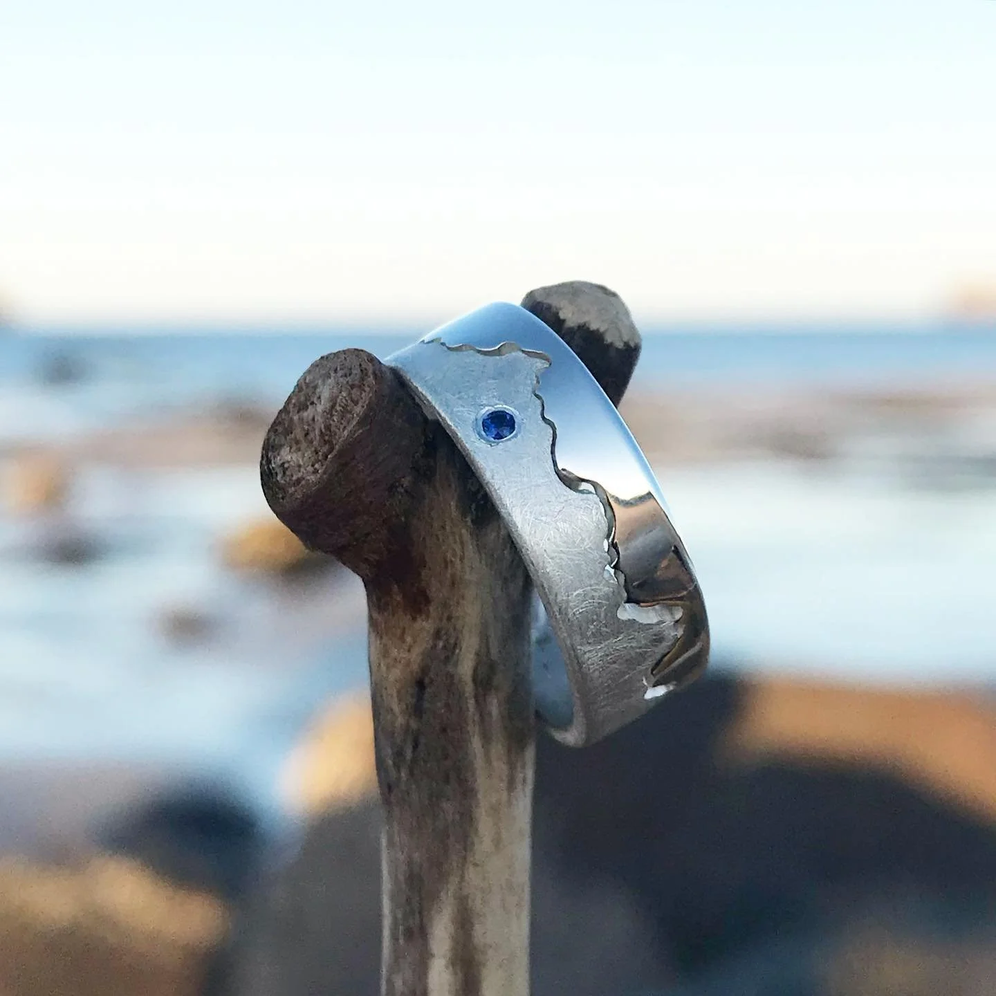Custom silver ring with a sapphire, personalised with the cornish coast