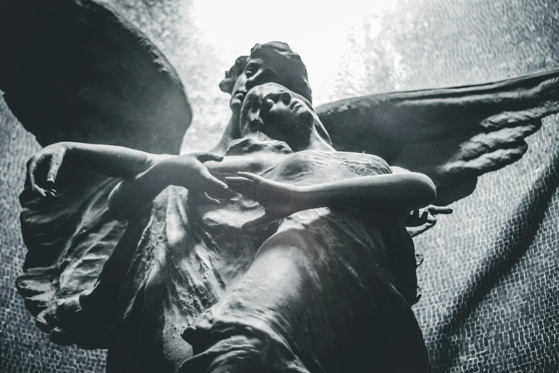 A statue of a winged creature holding a woman.