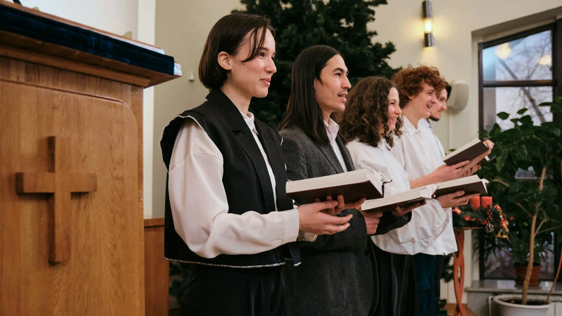Christian men and women singing with hope hymnals.