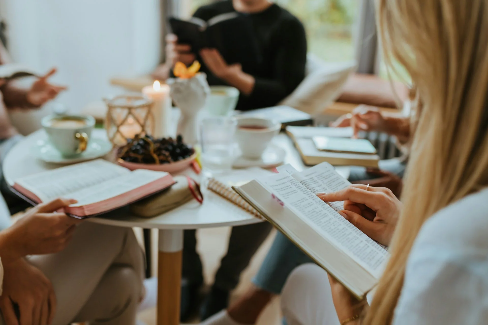 women sitting round a table doing a Bible study. Bibles are open. There are no workbooks in the study.