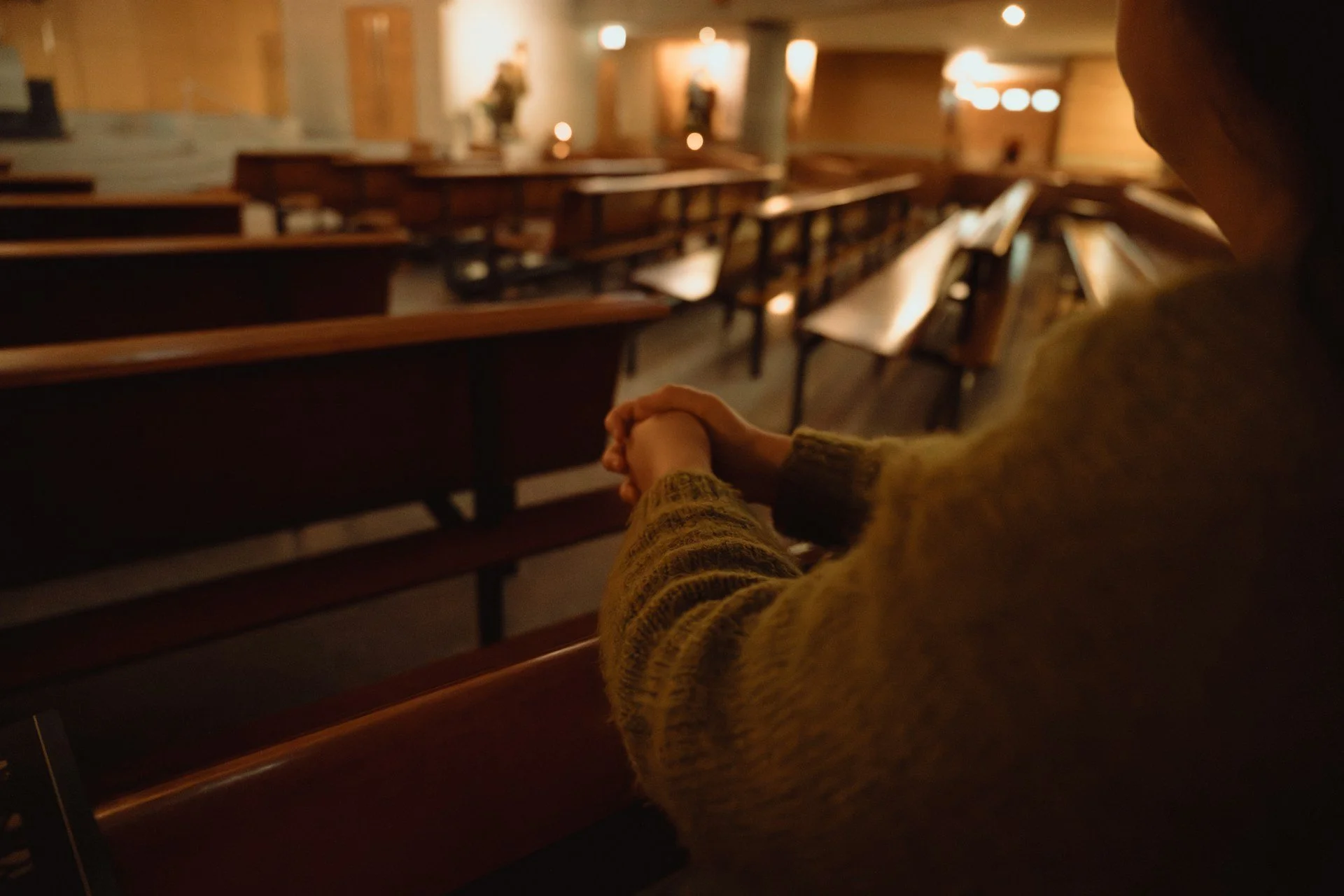An empty church with one person praying.