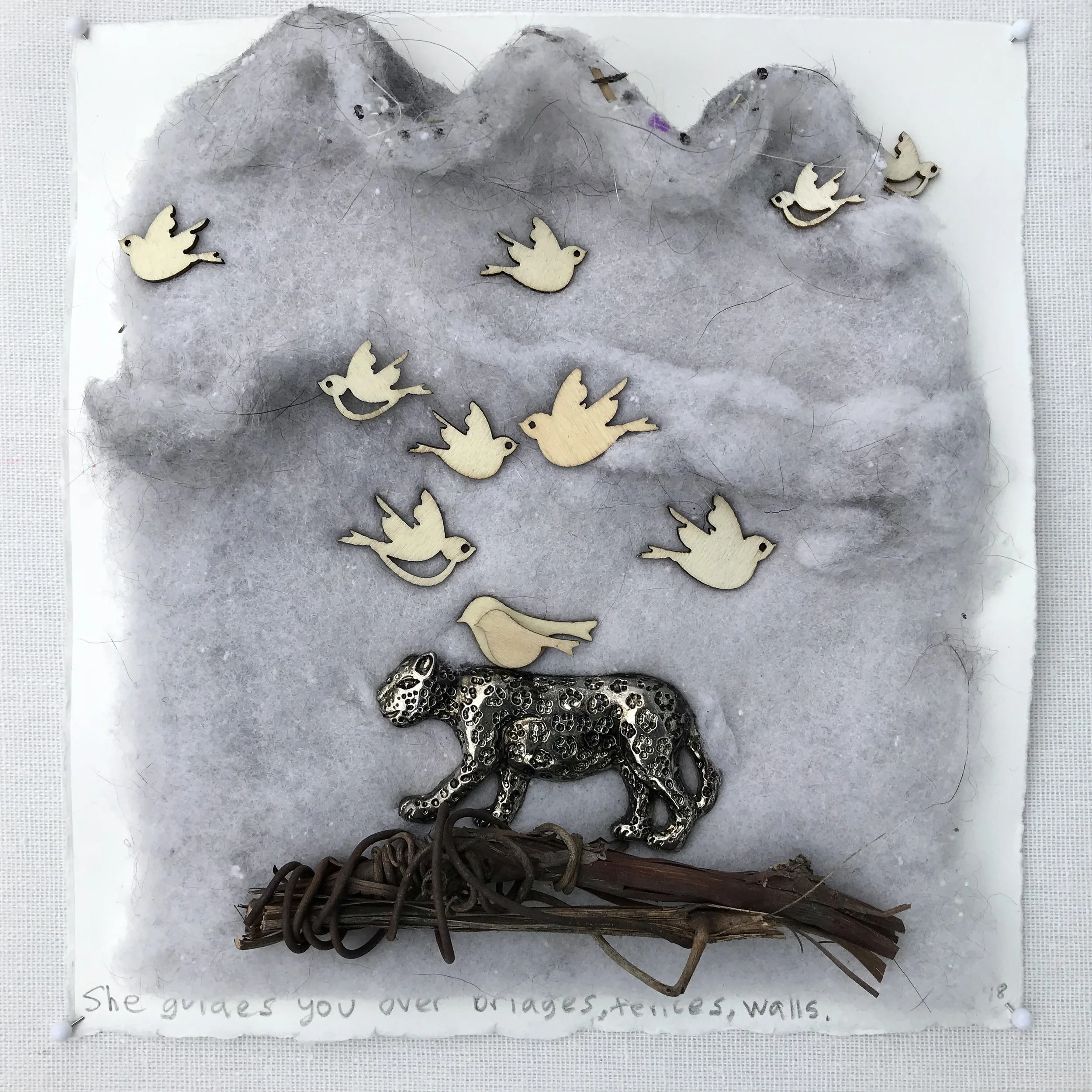 She guides you over bridges, fences, walls. - 2018 laundry lint, wire wrapped grape vine, wooden birds, metallic leopard on cotton rag paper