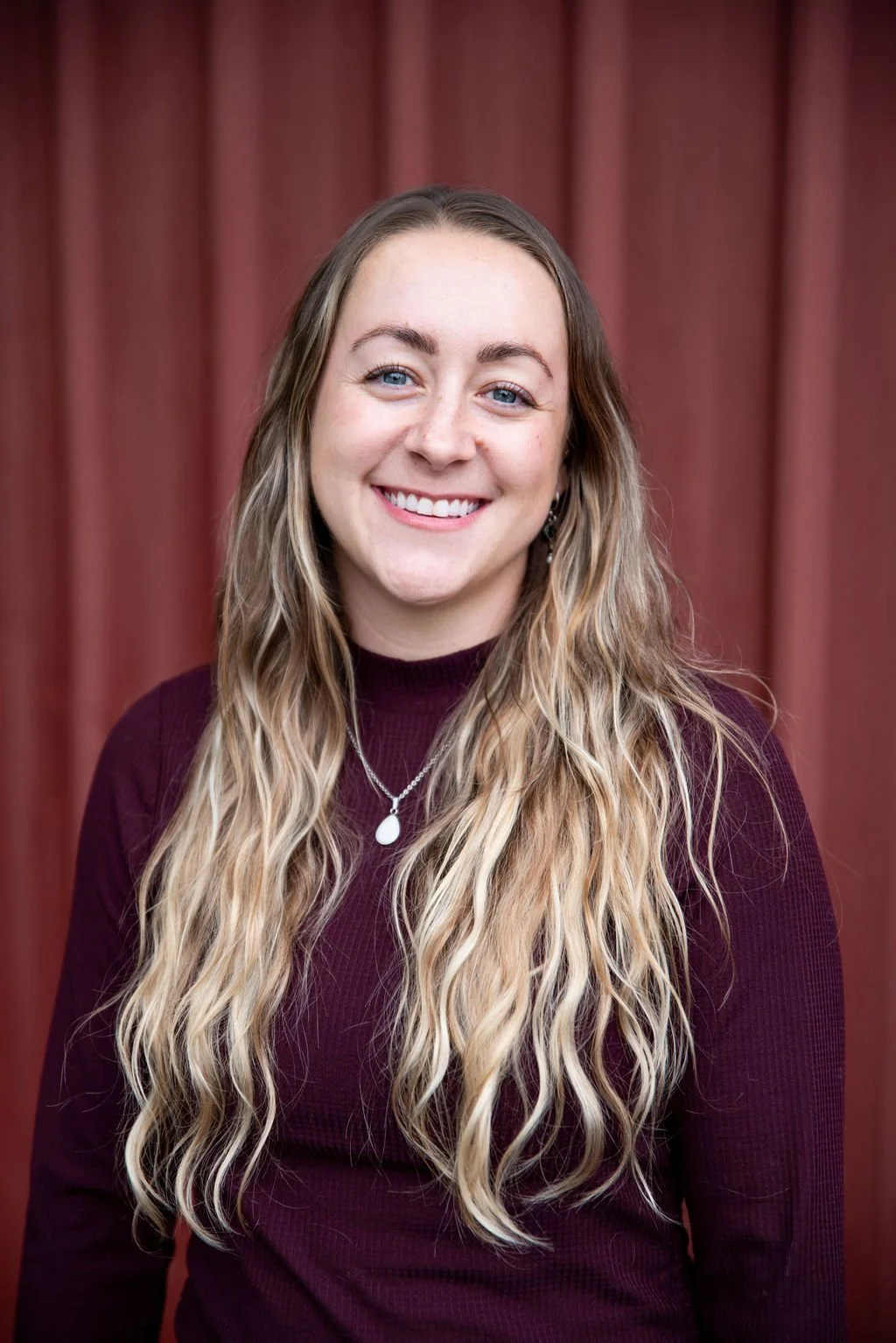 Postpartum doula Sydney smiles for professional photo in Portland, Oregon.