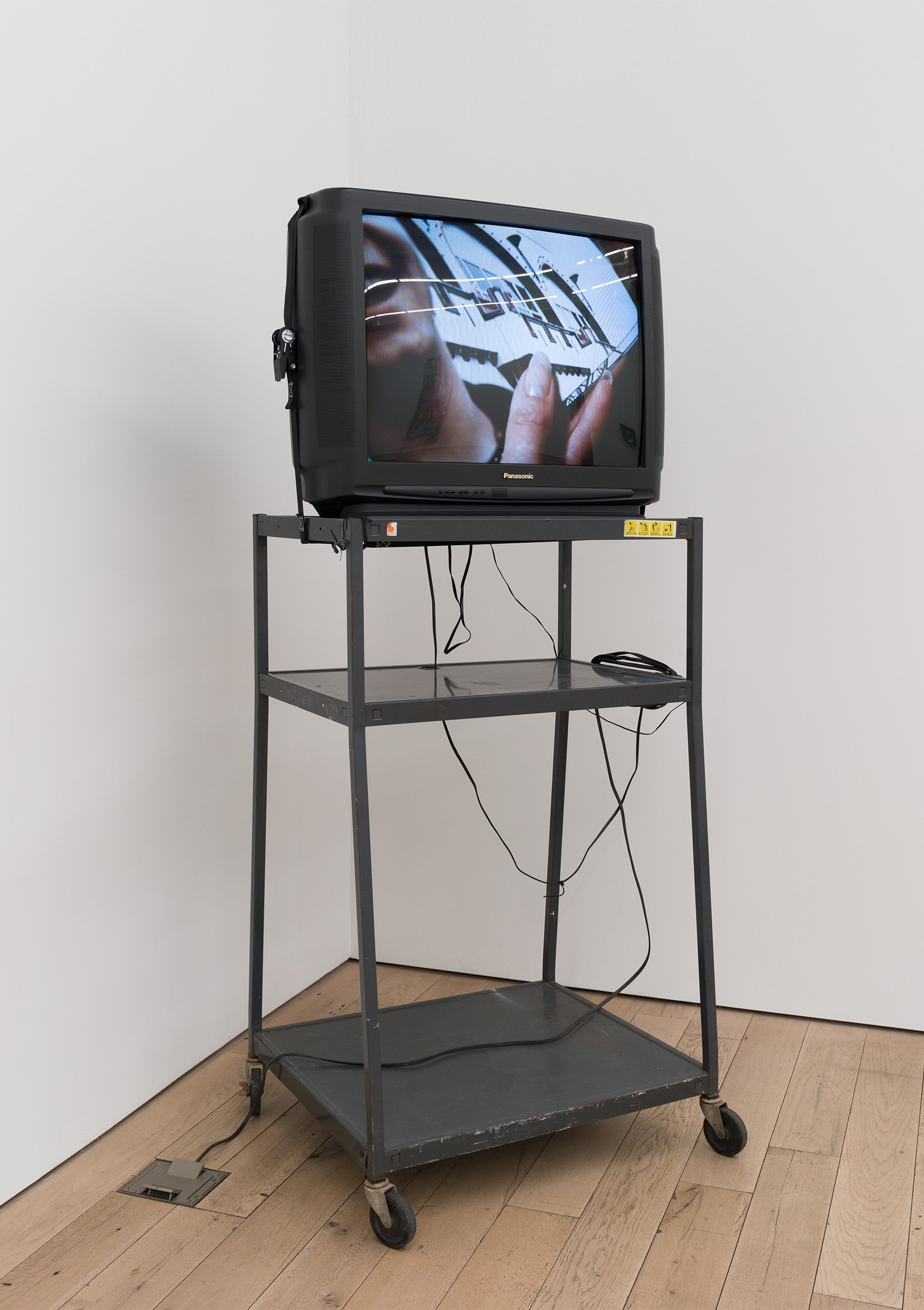  Bradley Kronz,  Chromatic , 2018, Media cart, tv, ratchet strap, 30 x 32 x 84 in 