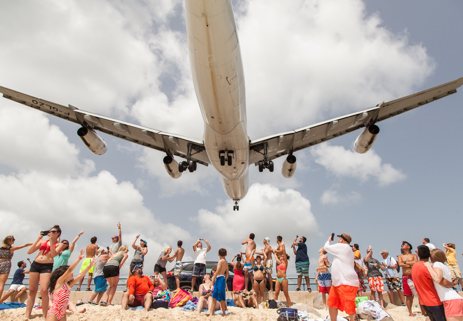  An Air France Airbus A340 lands at Juliana International Airport, passing over Maho Beach, a few feet above the tourists on the beach - Saint Martin 