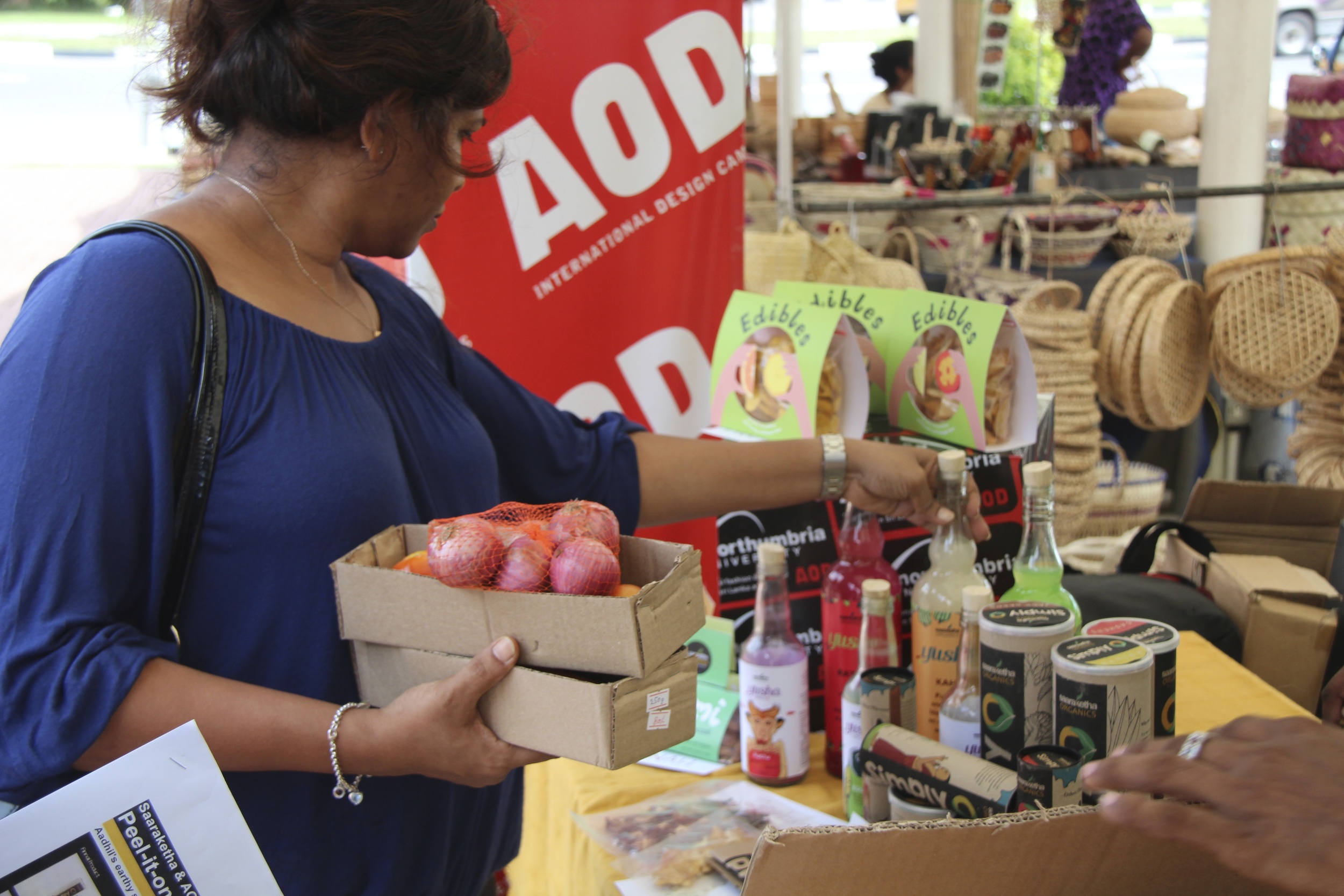 Customers of organics brand Saaraketha give feedback on student packaging concepts for a line of organic snacks and smoothies at a fair trade market in Colombo. 2014.