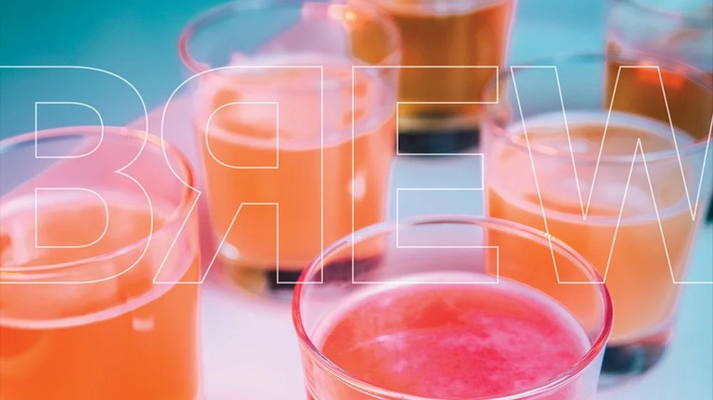 Several glasses filled with a pink and orange beverage, arranged on a surface with a blurred blue background.