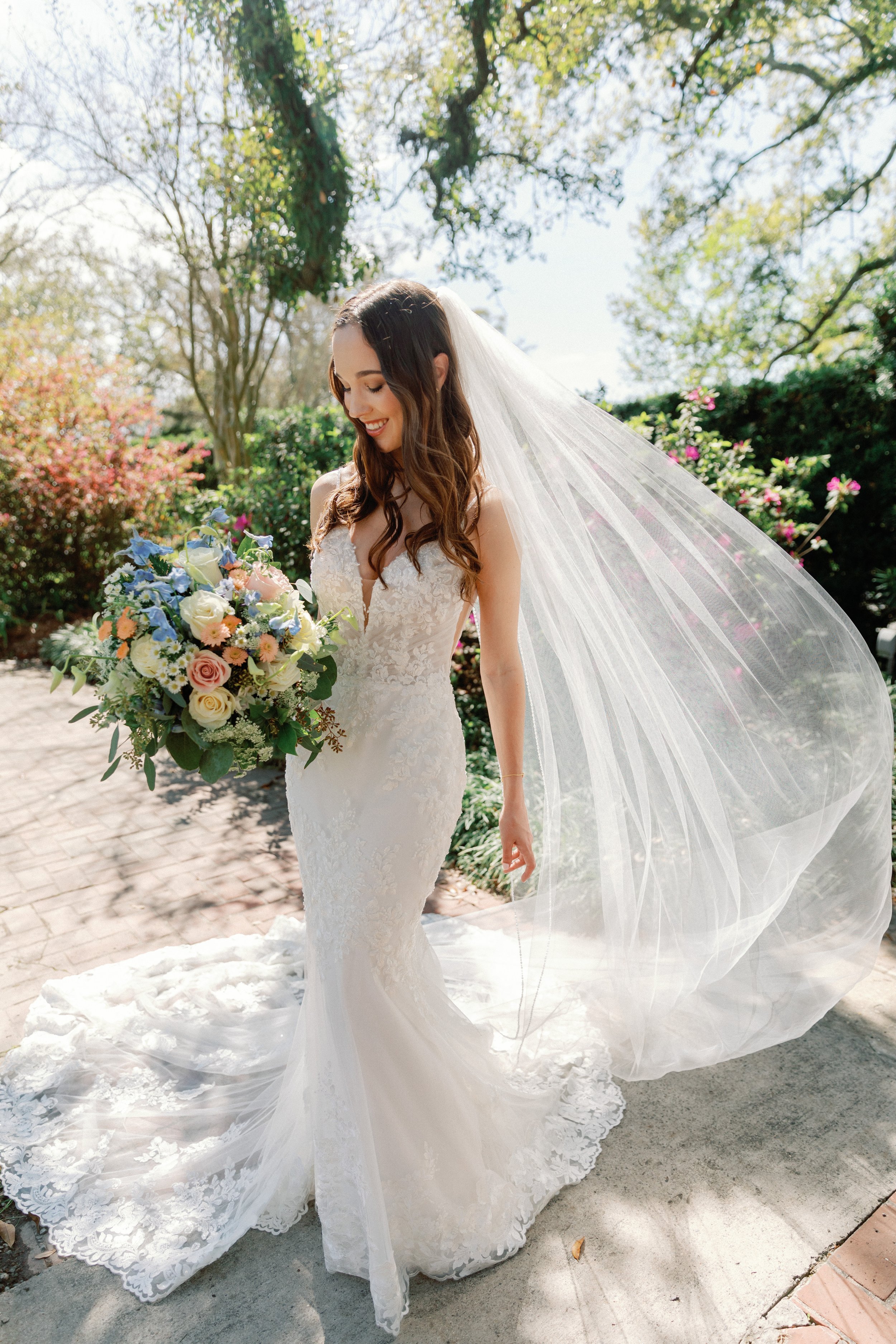 Bride in Botanical Gardens holding a large, colorful bouquet of flowers