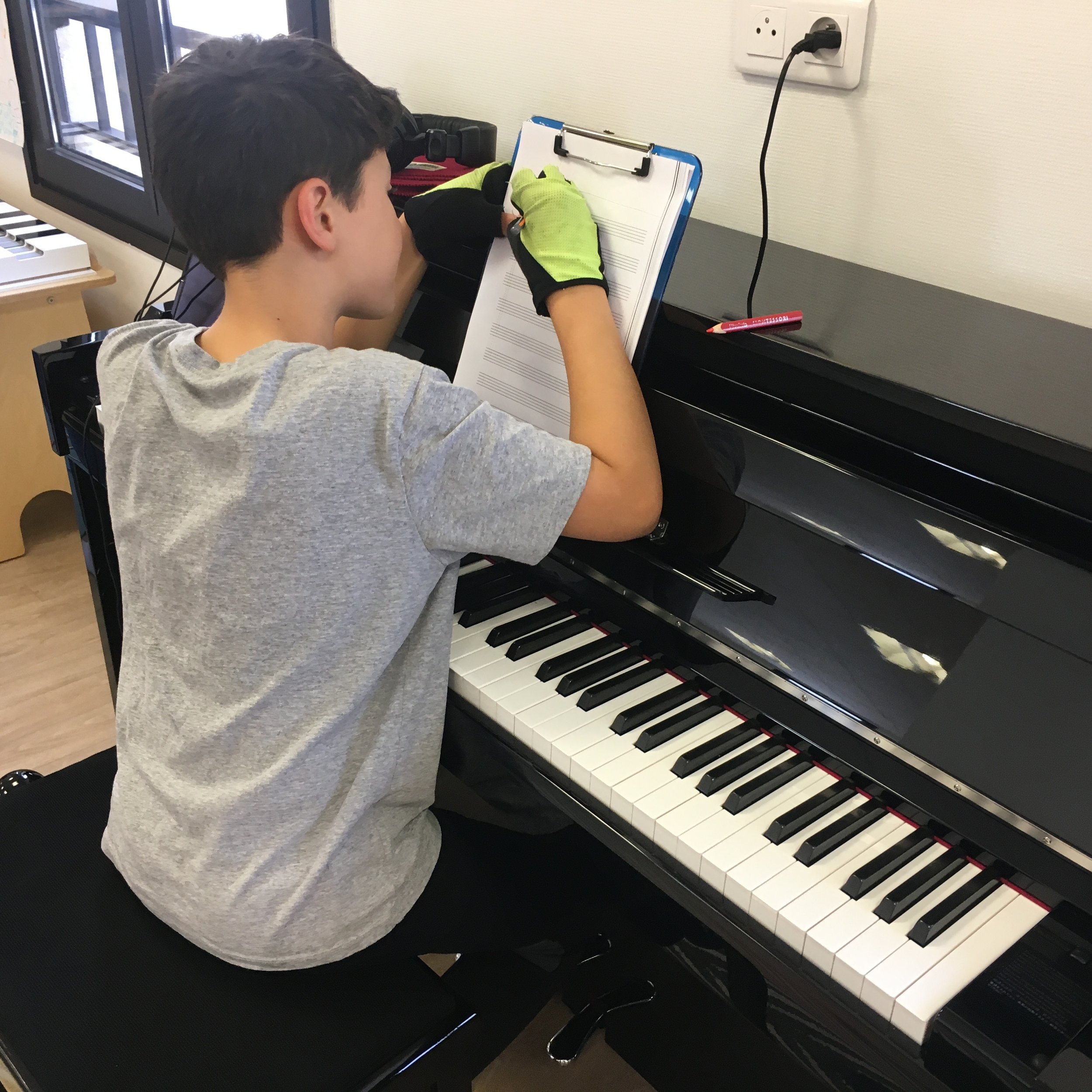 Sully composing his themes at the piano (wearing optional bicycle gloves).