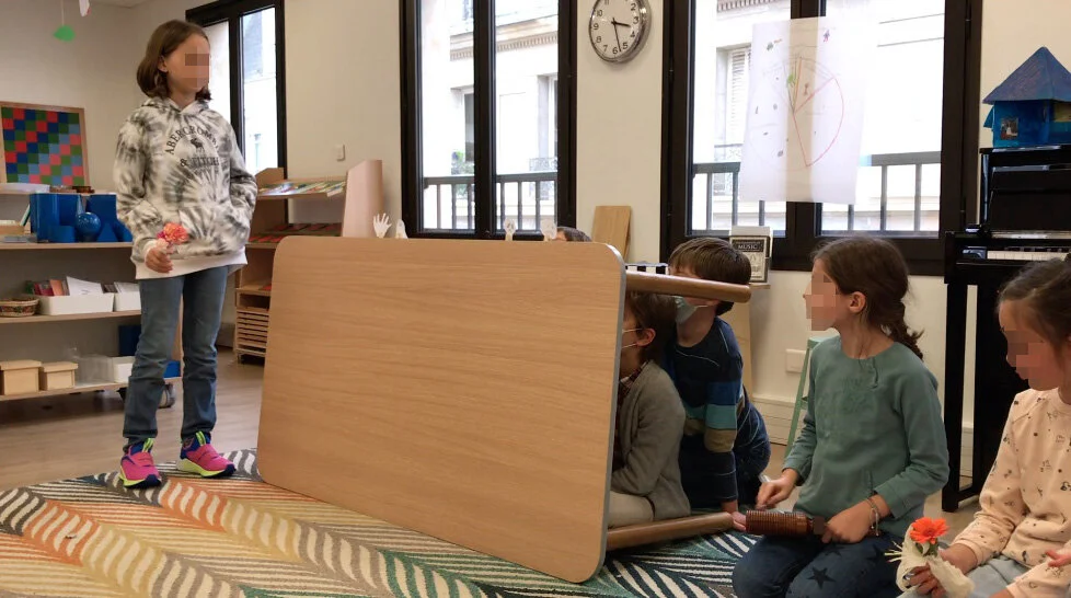 The children performing the puppet show. (The puppet on the left is a disembodied hand!)