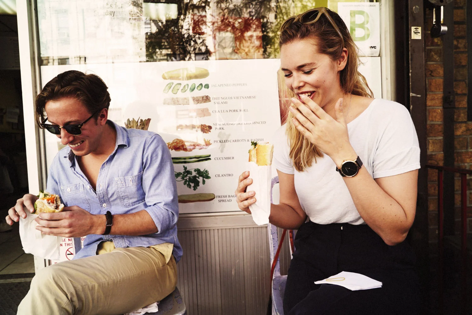 Boy and girl laughing while eating Banh Mi.jpg