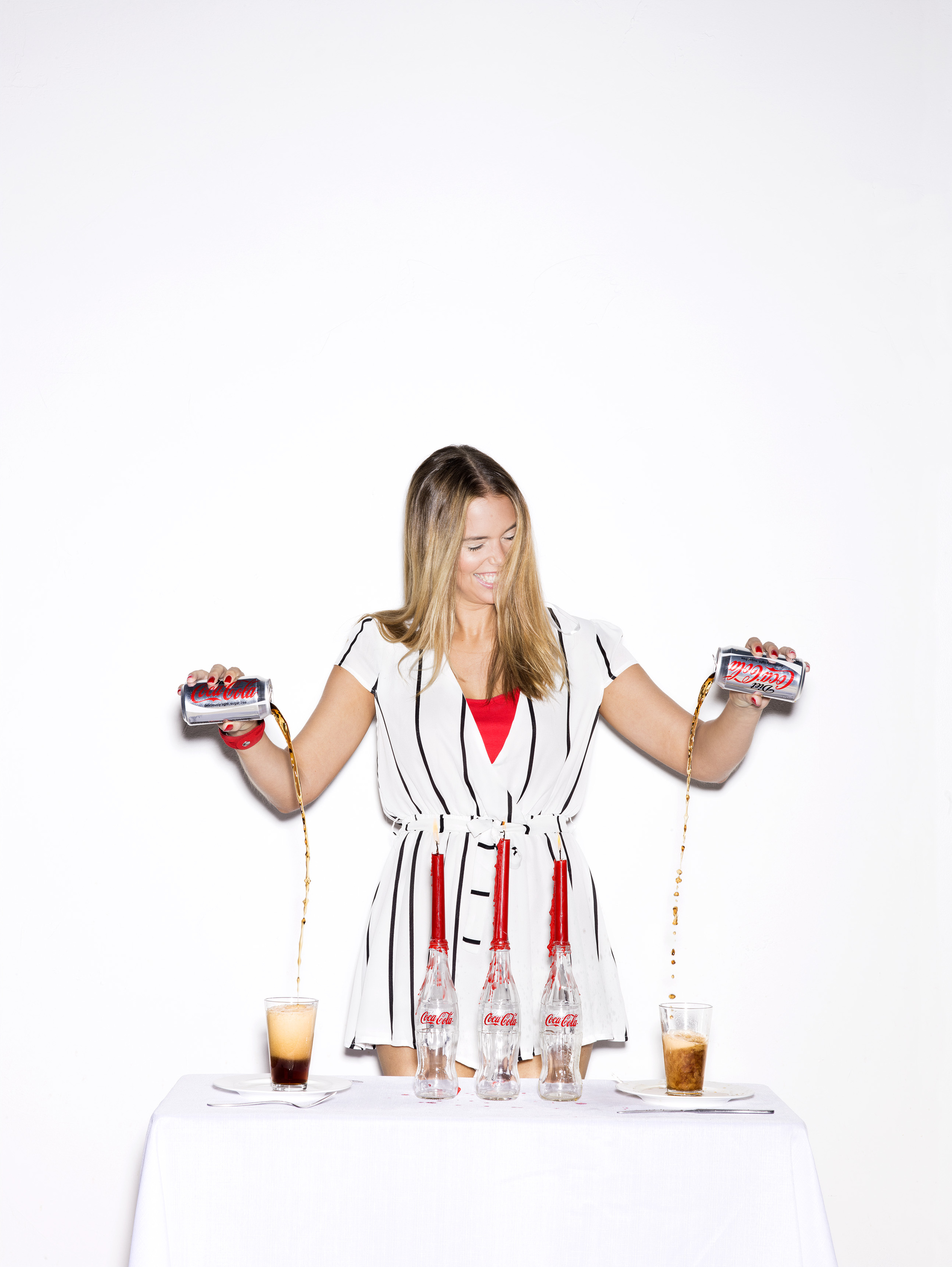Girl pouring diet coke into glasses.