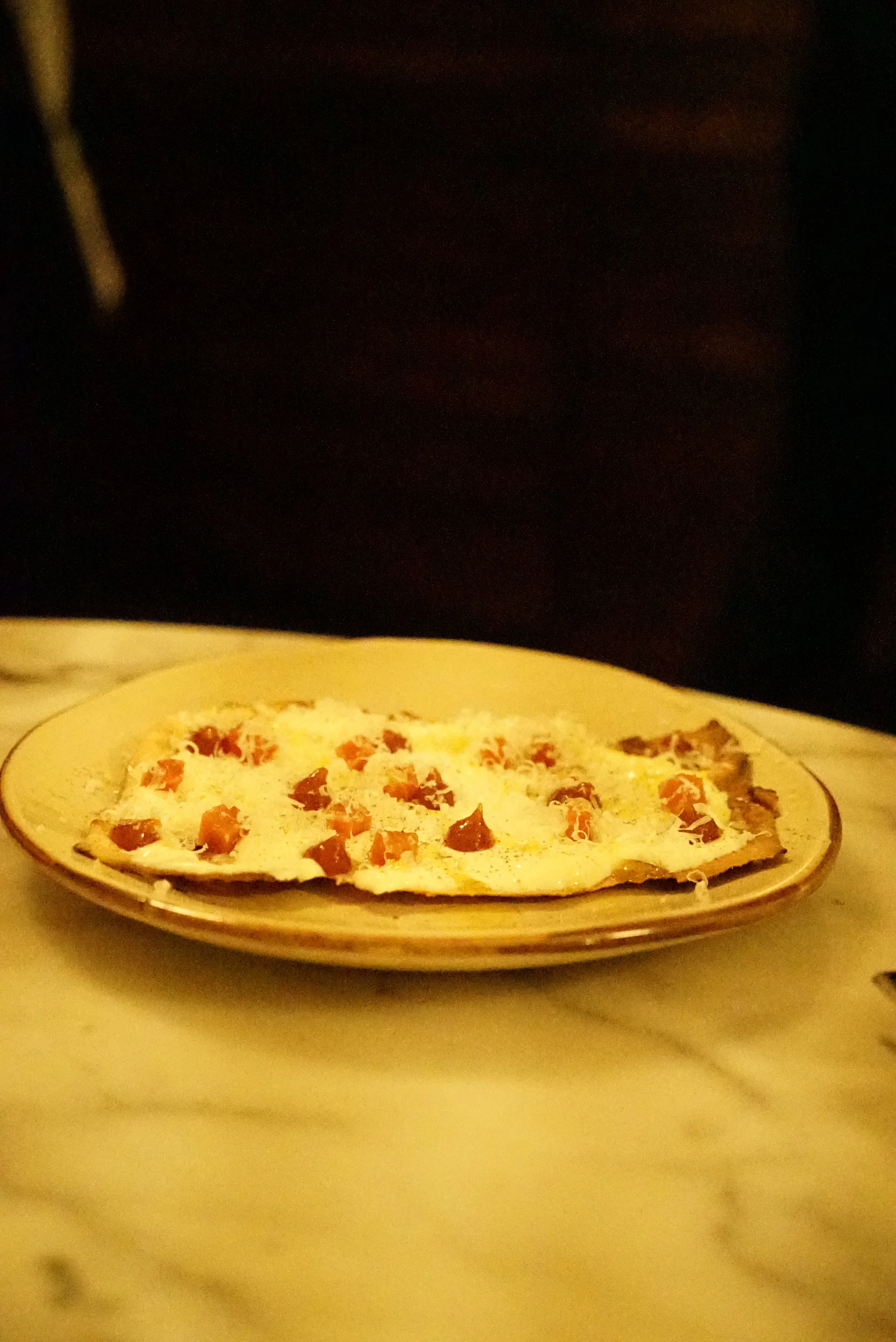 Grilled pan carasau crostini with prosecco cheese, quince and black pepper.