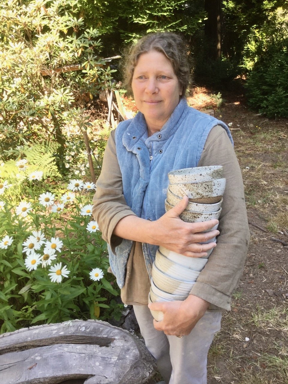 Colleen with stack of bowls and daisies.jpeg