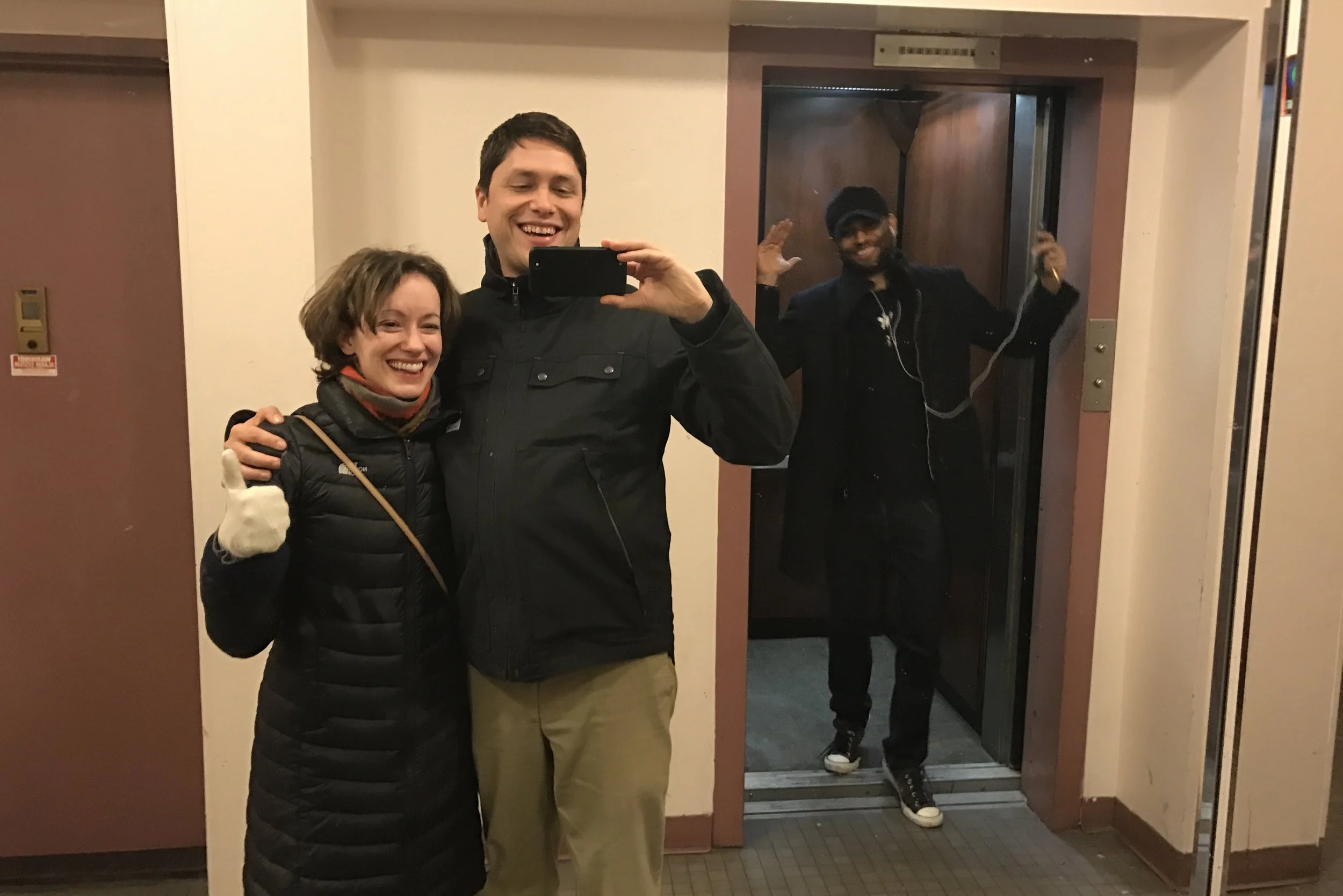 two people in front of an elevator one person in an elevator