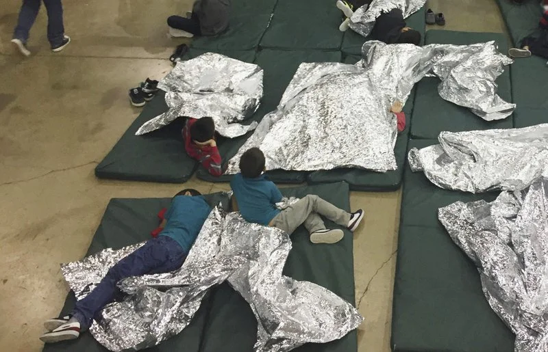 The children are given foil-like blankets for warmth