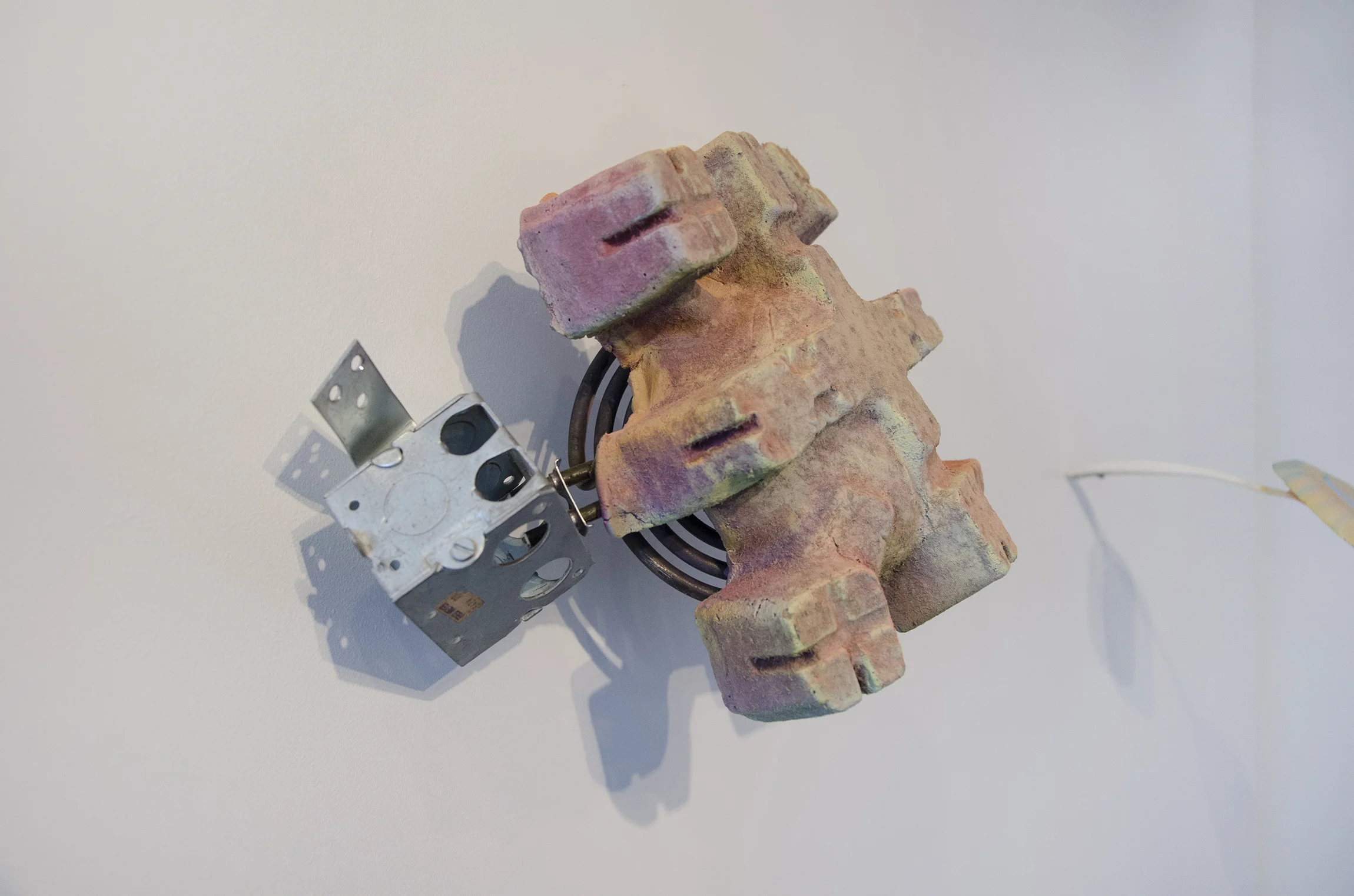 Cooked Up (Detail) Electric outlet box, stove element, cement, acrylic paint. 14”x15”x8” 2019 Photo Credit: Here/There Gallery