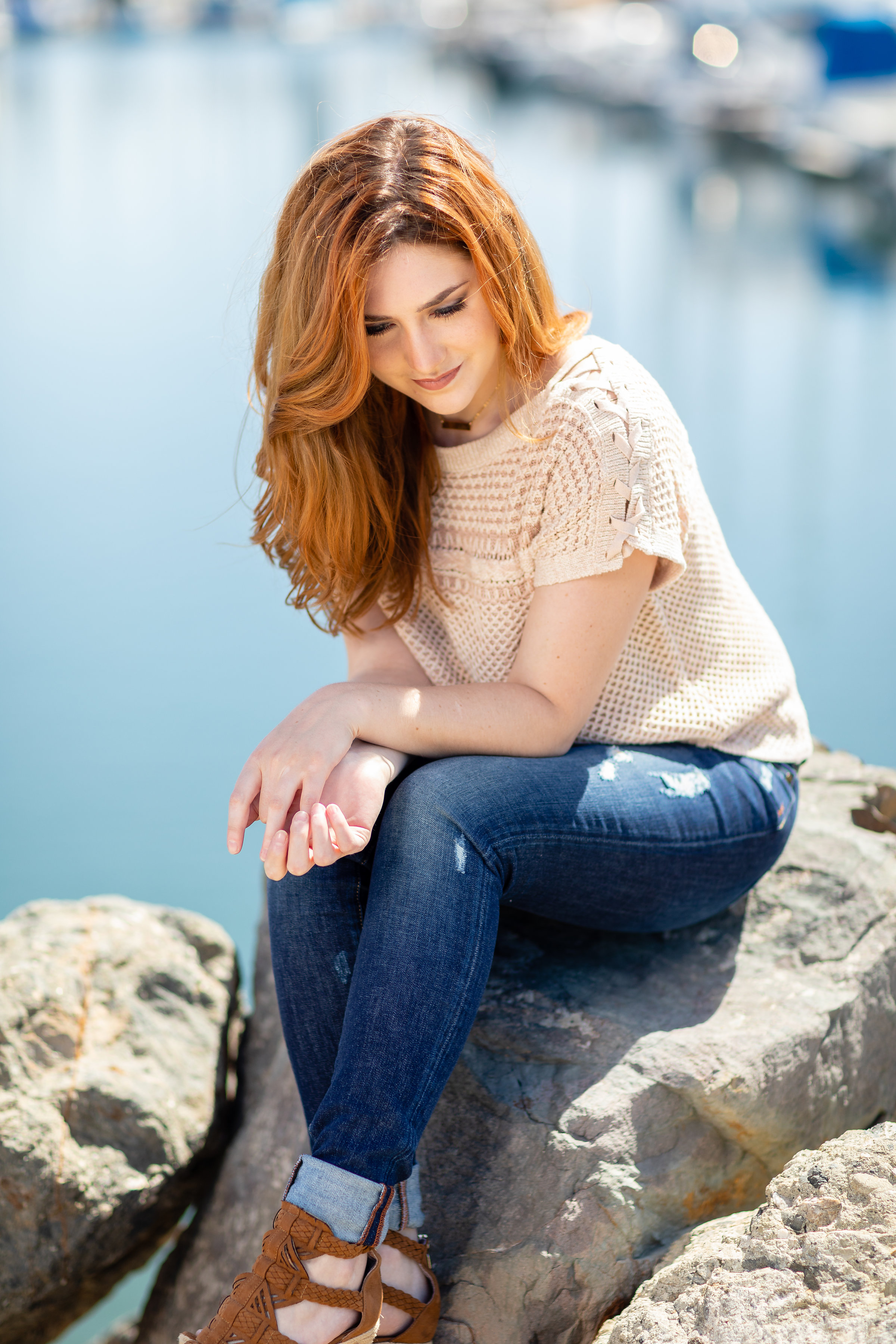 Woman sitting on rocks along the harbor.jpg