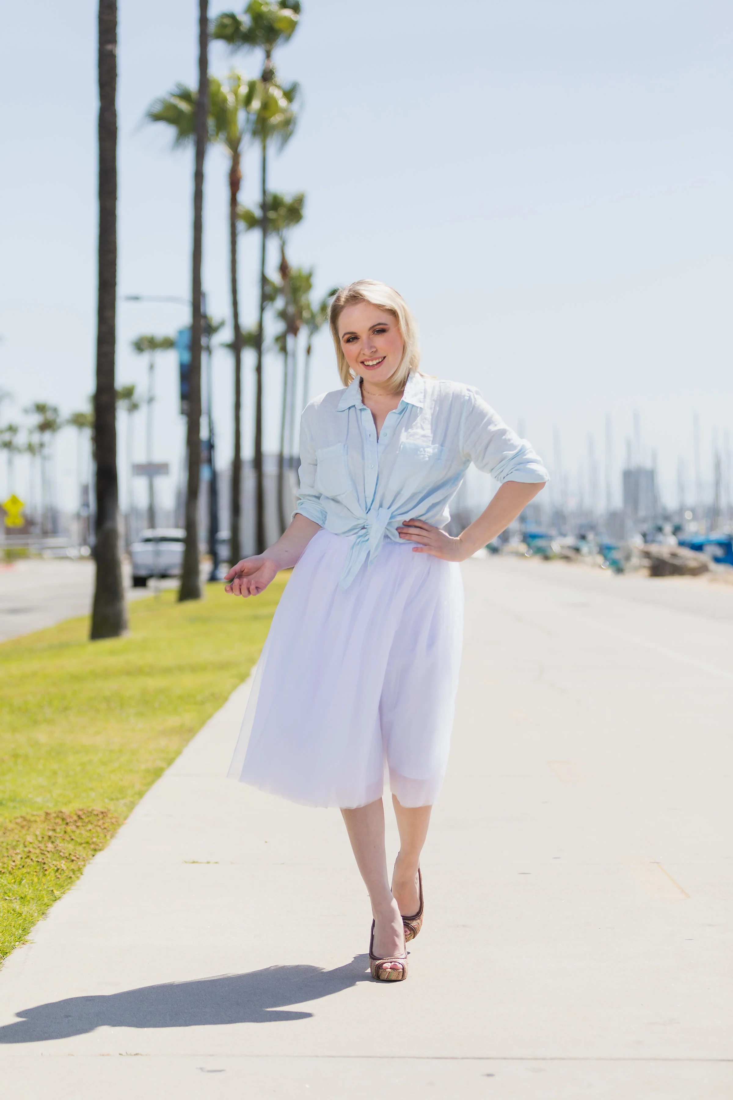 Pretty blonde woman walking down the harbor in heels and a tulle skirt.jpg