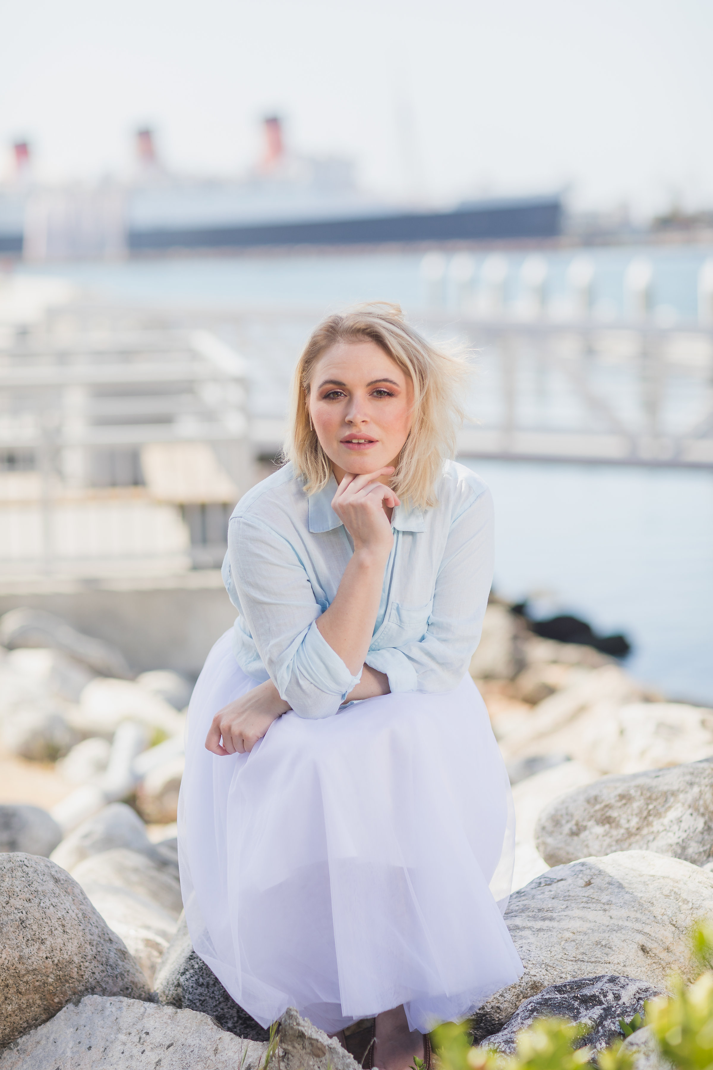 Beautiful edgy female blonde model sitting on the bank of a jetty.jpg