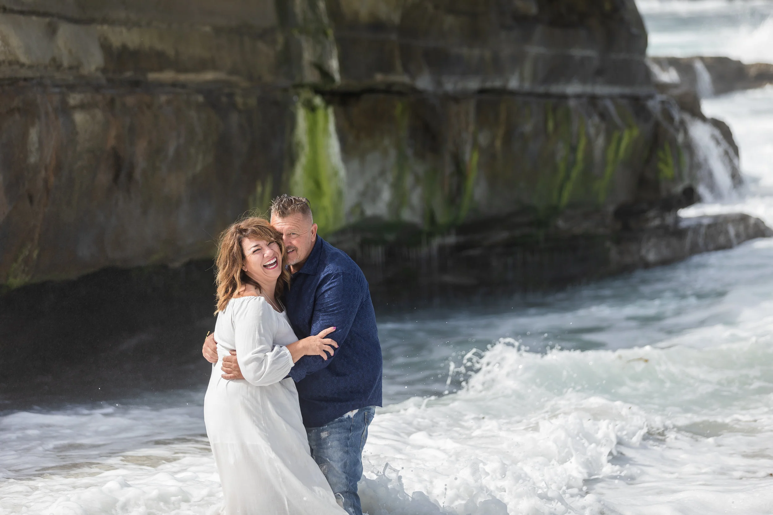 Husband and wife playing in the beach waves.jpg