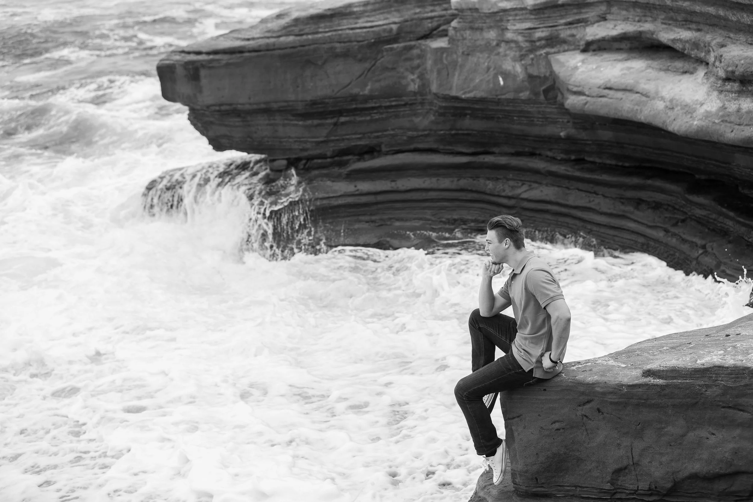 Adult male sitting on rock overlooking ocean thinking.jpg