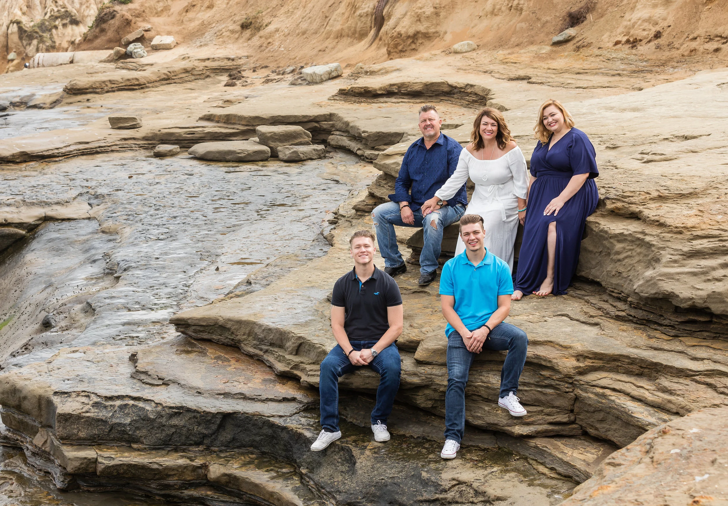 Family Beach Portrait on the rocks in shades of blue and white.jpg